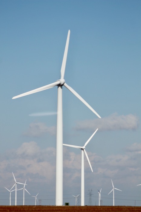 Wind turbines in an open field under a blue sky