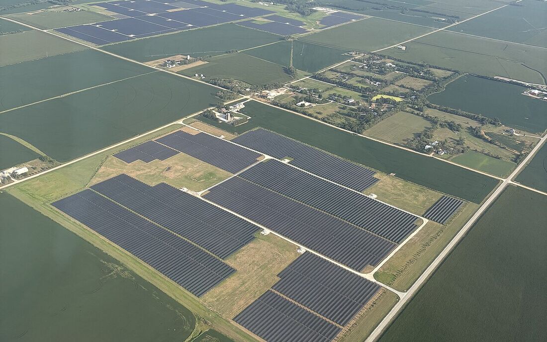 Aerial view of a large solar farm surrounded by farmland
