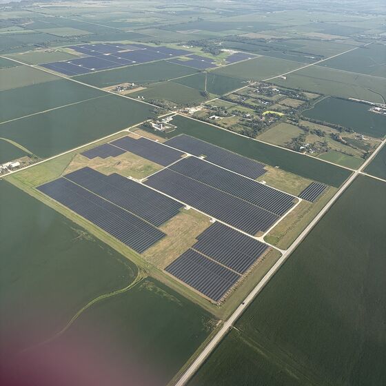 Aerial view of a large solar farm surrounded by farmland